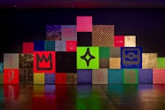 A triangular installation of squares of different colours and patterns.