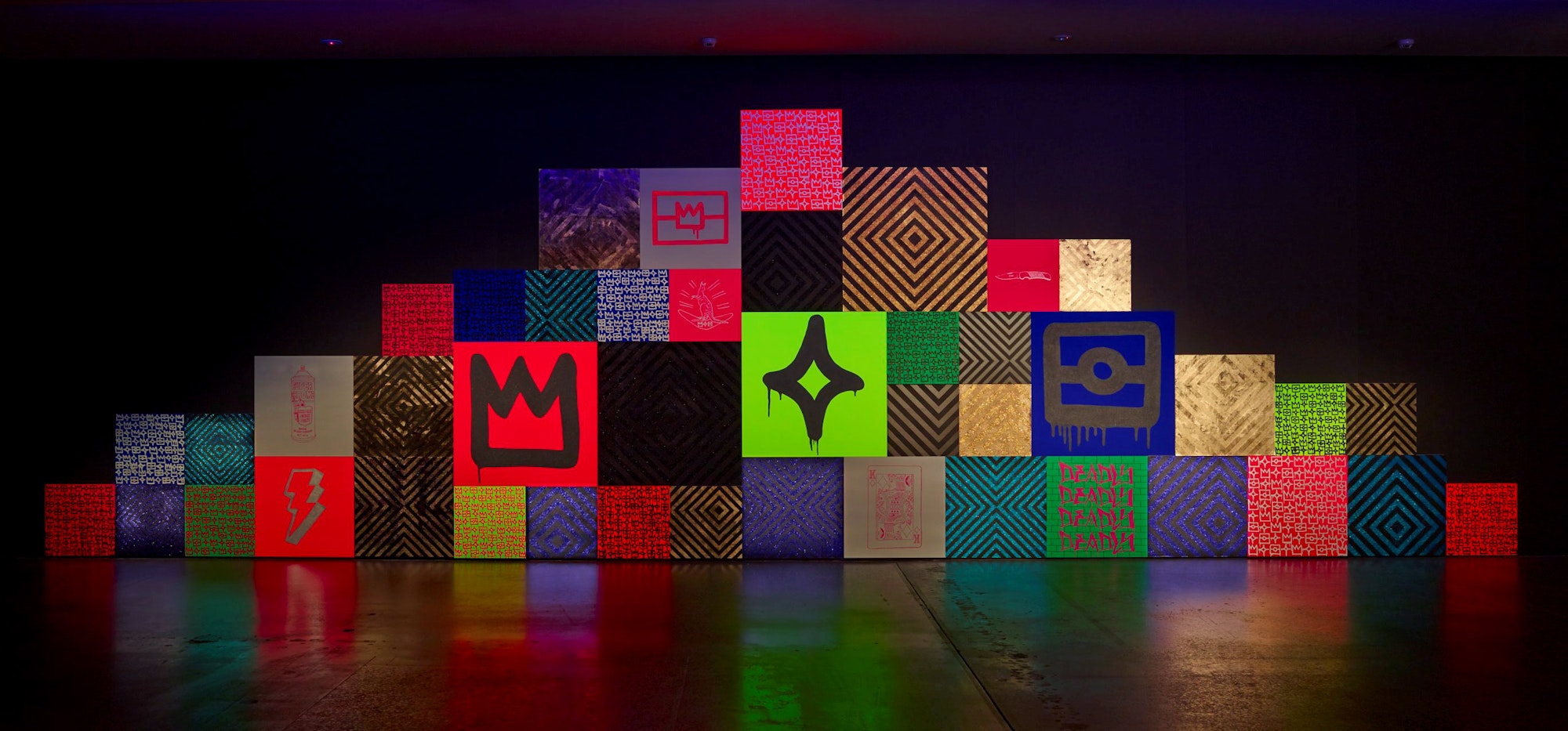 A triangular installation of squares of different colours and patterns.