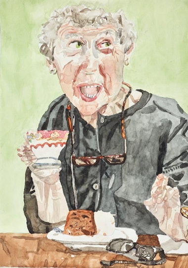 A person holding a cup and sitting at a table with cake on a plate