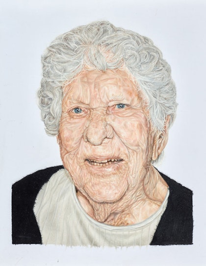 The head and shoulders of a person with short curly grey hair