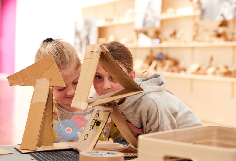 Two  children at a table with cardboard structures