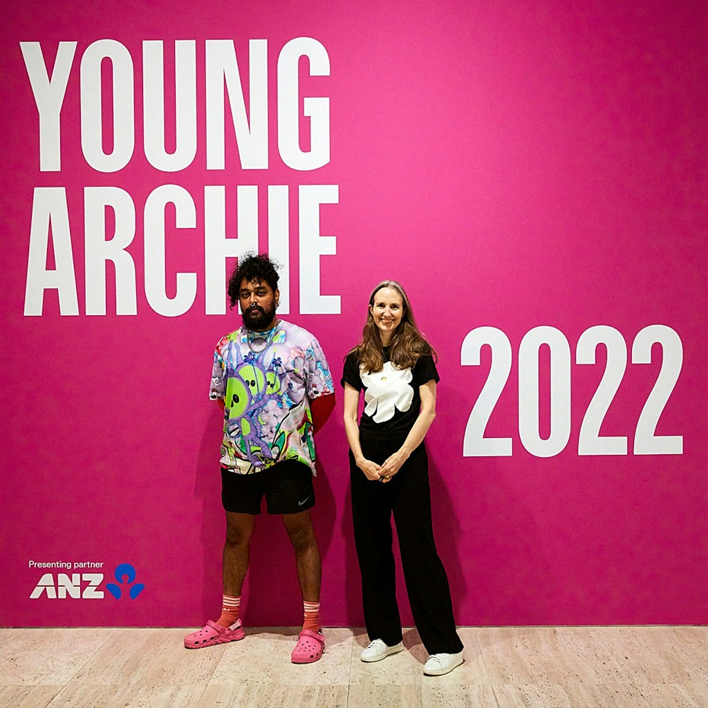 Two people stand in front of a wall on which is written Young Archie 2022, presenting partner ANZ