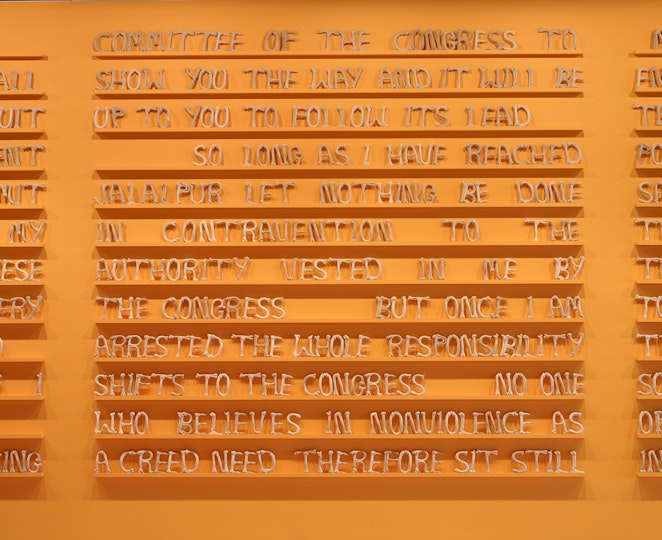 Rows of shelves on a wall hold capital letters that form words