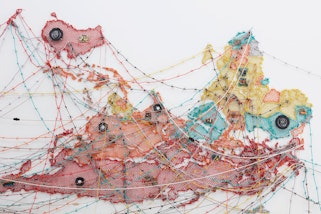 An upside-map of part of the world, including Australia, made of woven wires and audio components