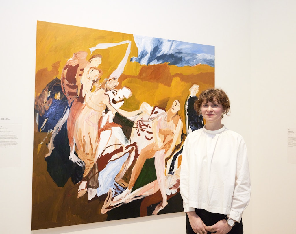 A person stands in front of a large figurative painting
