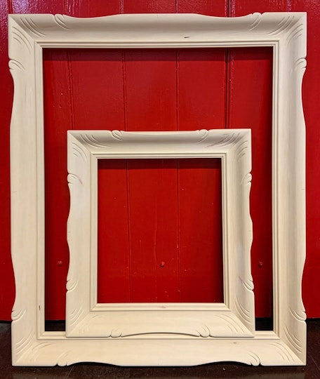 Two similar carved, unpainted picture frames - one is about half the size of the other