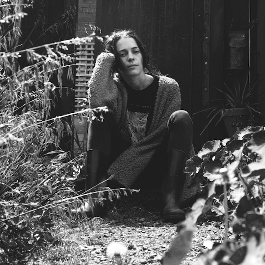 A person sits on the ground outdoors