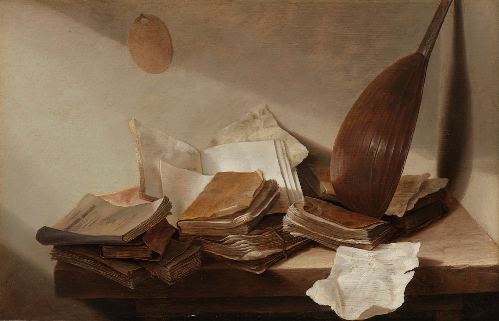 Books, paper and a stringed instrument on a table