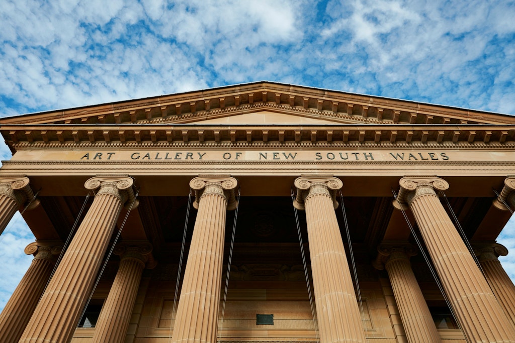 Looking up at a sandstone building with 'Art Gallery of New South Wales' written above classical columns