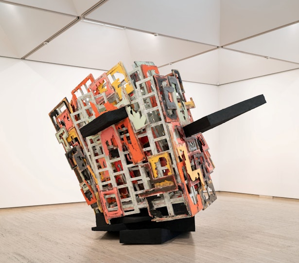 A large rectangular sculpture made of a combination of coloured ladder-like pieces and other shapes with large black projections