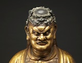 The head and shoulders of a bronze and gold coloured statue