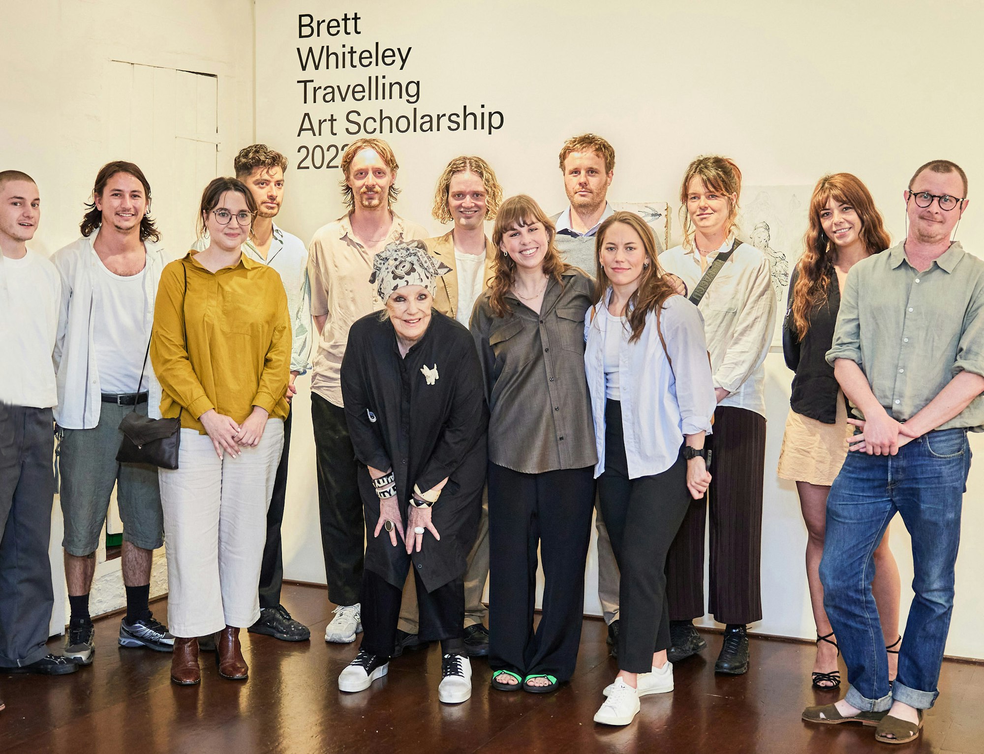 A group of 13 people standing in front of a sign saying 'Brett Whiteley Travelling Art Scholarship 2022'