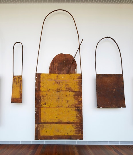 Three metal bag-like objects in different sizes, mounted on a wall