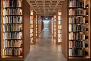 A wide passageway between rows of bookshelves stacked with books