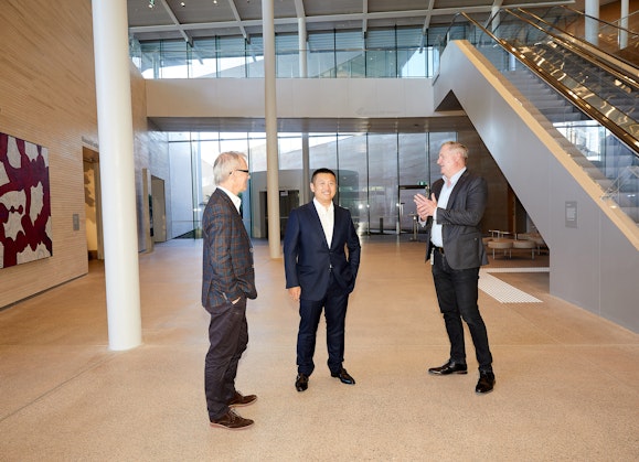 Art Gallery of New South Wales director Michael Brand, Aqualand managing director Jin Lin, and Art Gallery director of development John Richardson, in the Aqualand Atrium of the Art Gallery’s new building. Artwork in background: Betty Kuntiwa Pumani ‘Antara’ 2017, Art Gallery of New South Wales, acquired with funds provided by the AGNSW Board of Trustees 2017 © Betty Kuntiwa Pumani. Photo © AGNSW, Jenni Carter