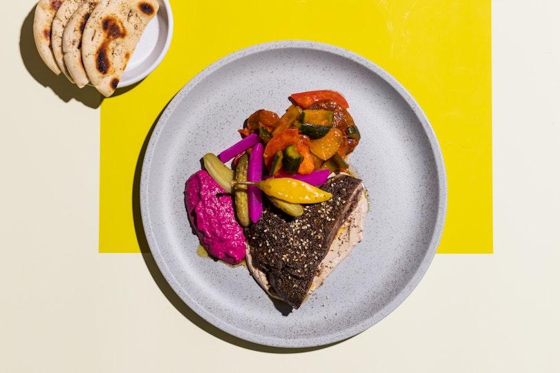 Food on a plate with a small side plate of flat bread