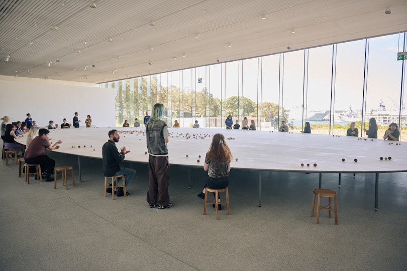 People at an enormous table making small spherical objects