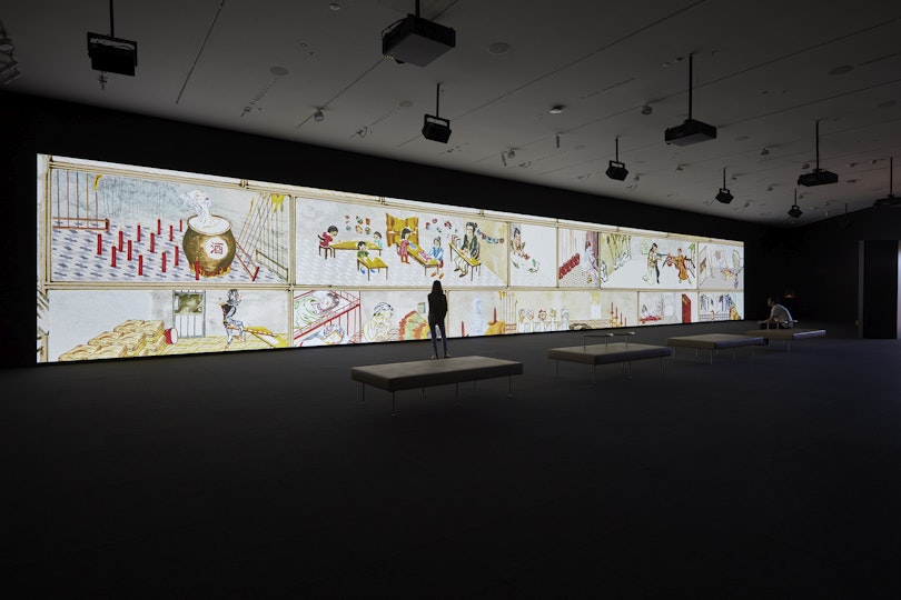 An artwork on an enormous screen in a dark room