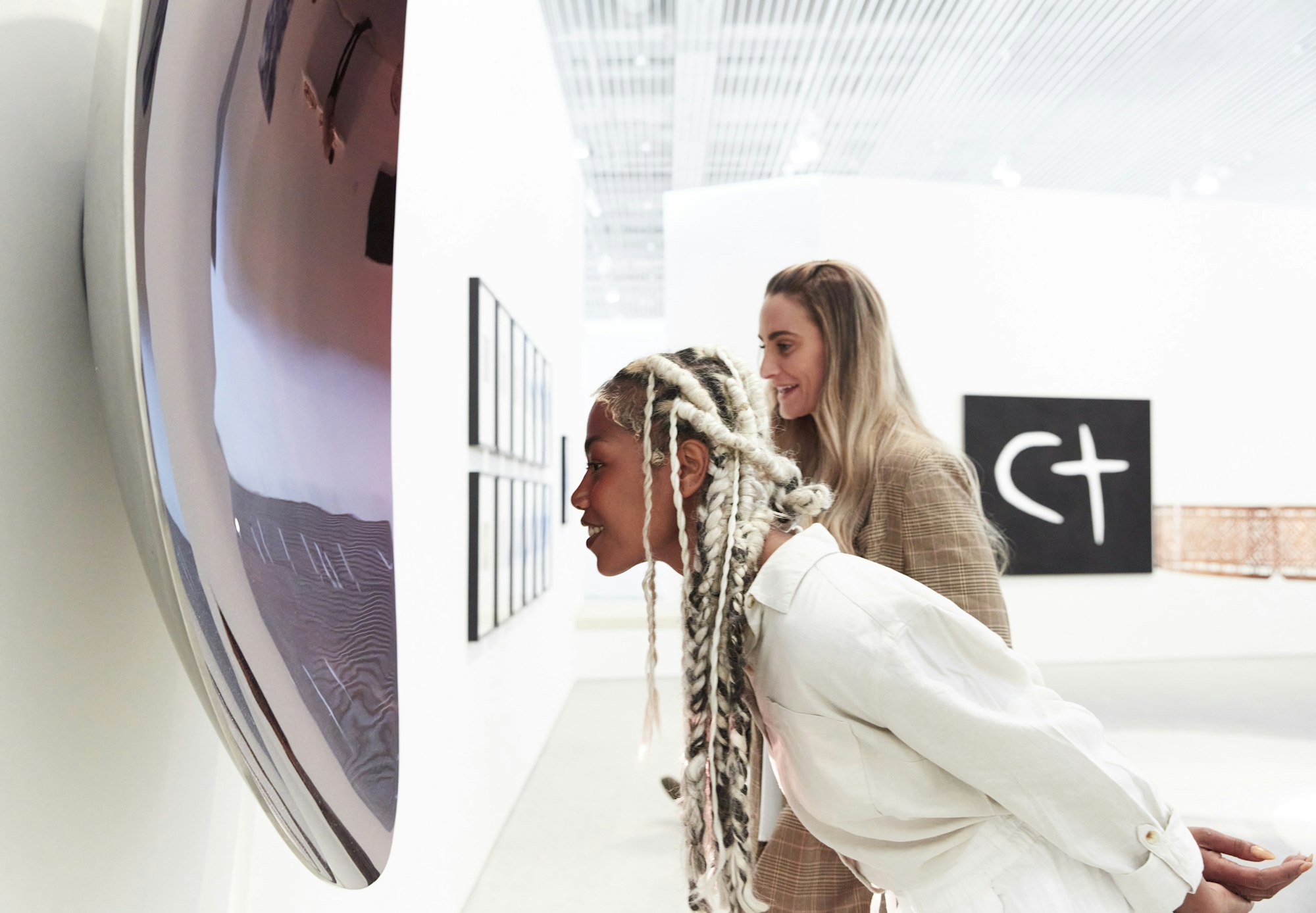 Two people looking at art on a wall