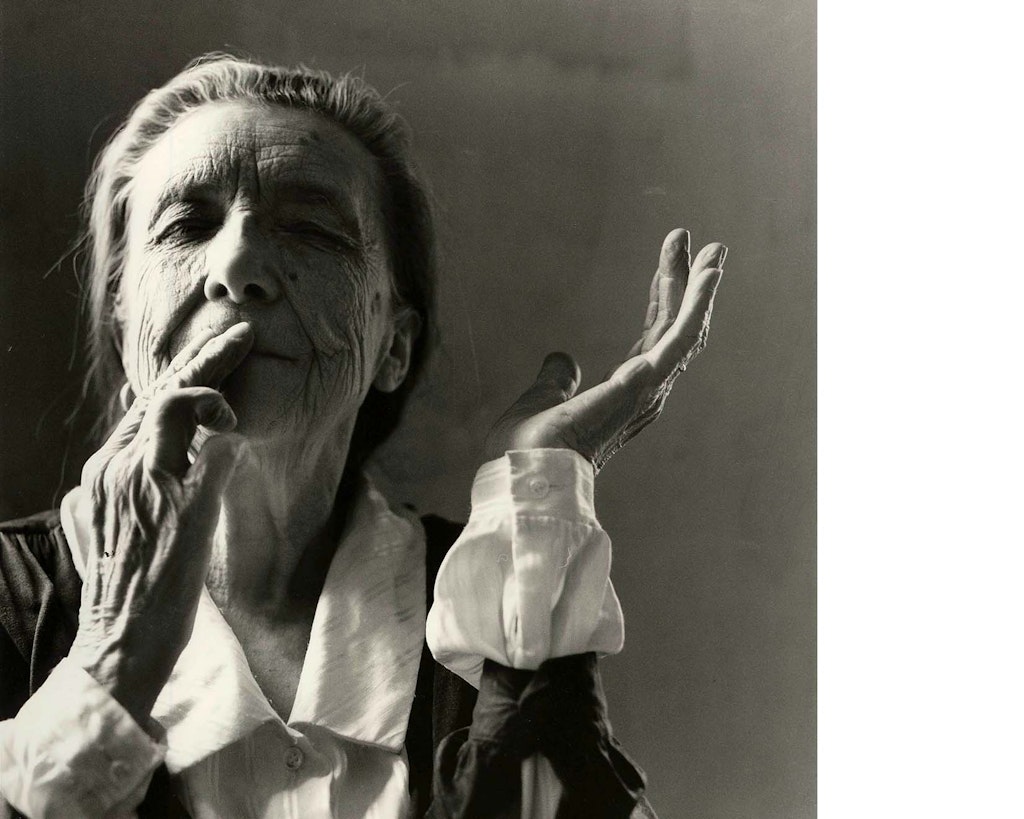 Black and white portrait of Louise Bourgeois wearing a white shirt and black jacket with grey hair pulled back.