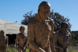 Bronze figures of four people walking