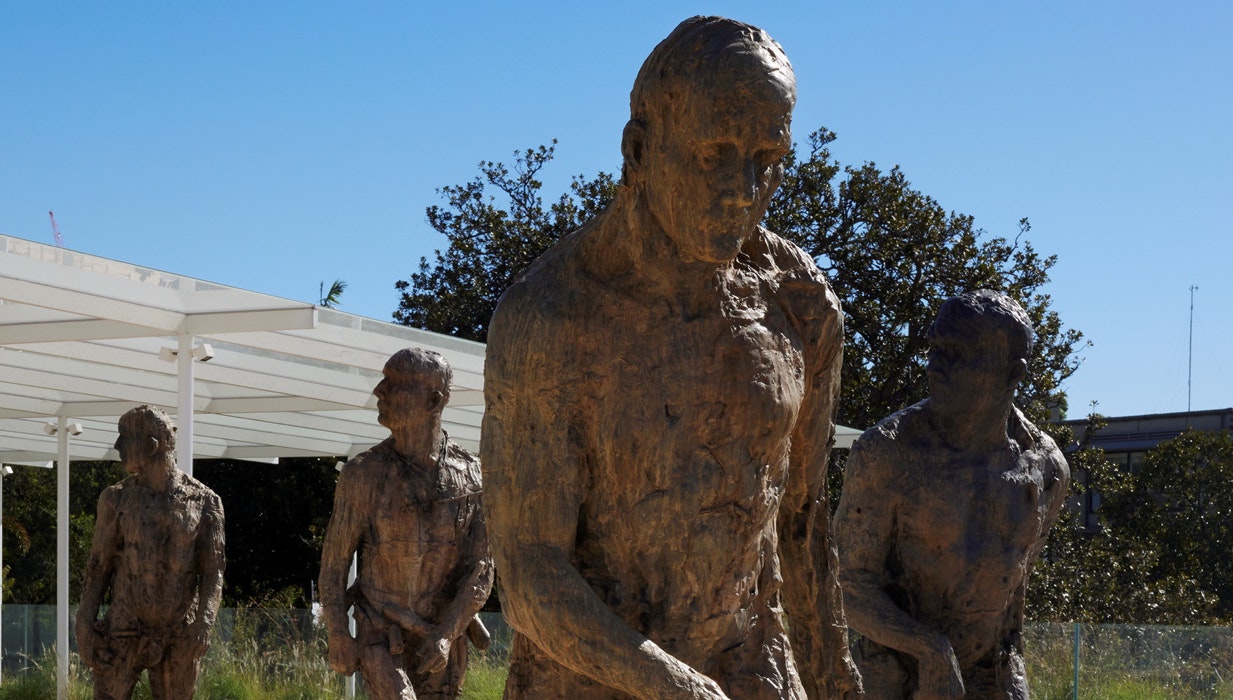 Bronze figures of four people walking