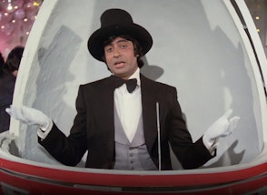 A person wearing a hat, gloves, shirt, bow tie, waistcoat and jacket inside a domed structure