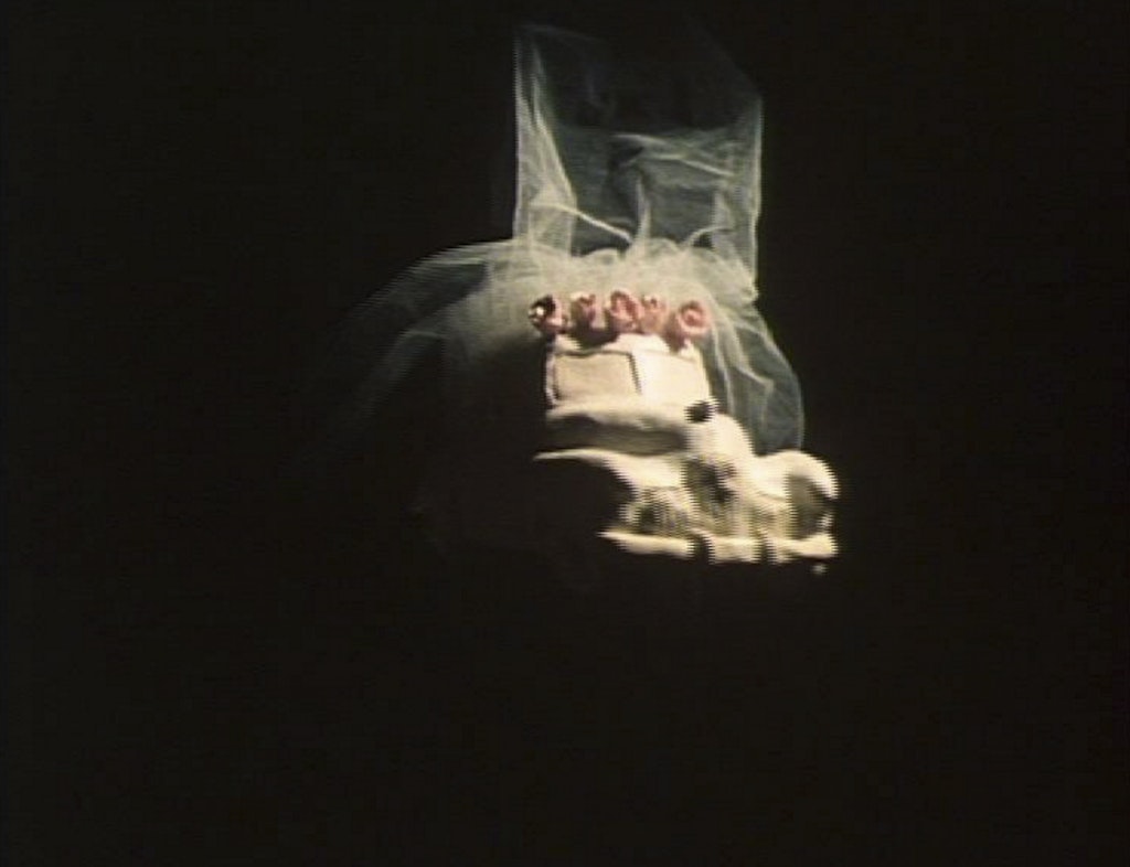 A ceramic car with a bridal veil attached to its roof