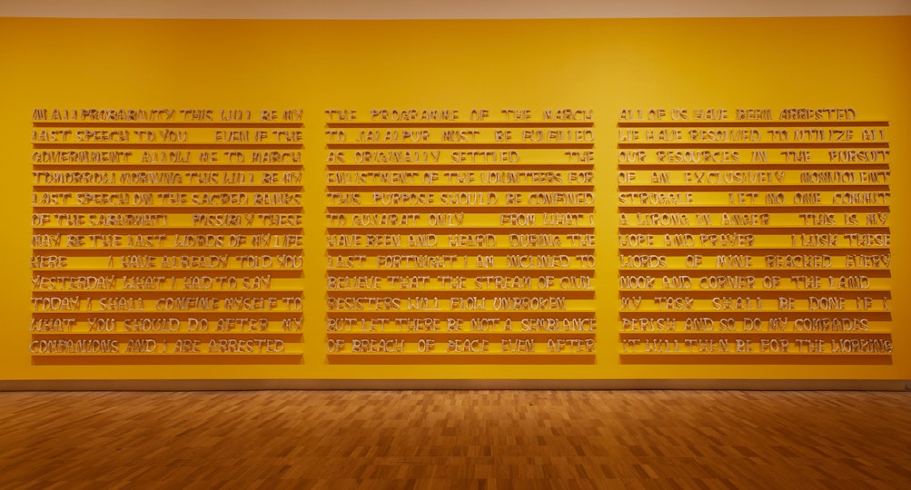 Three blocks of text arranged in rows on a yellow wall