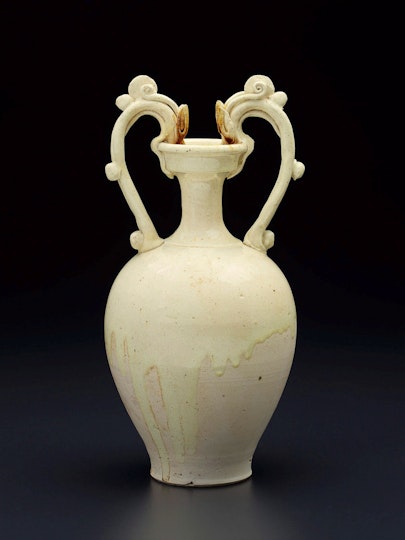 A ceramic vessel with two curved handles like the heads and necks of dragons