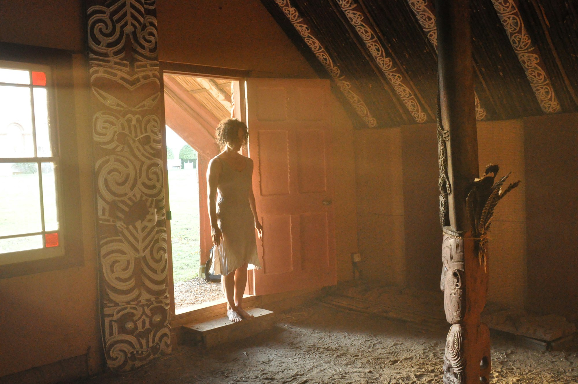 A person on the threshold of a dirt-floored room