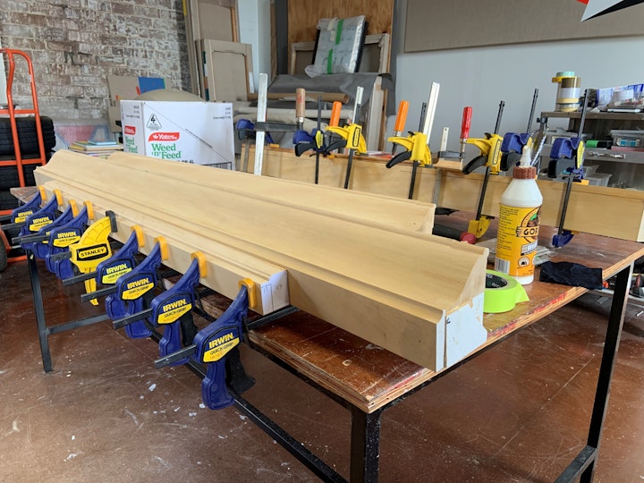 Pieces of a wooden frame gripped to a workbench