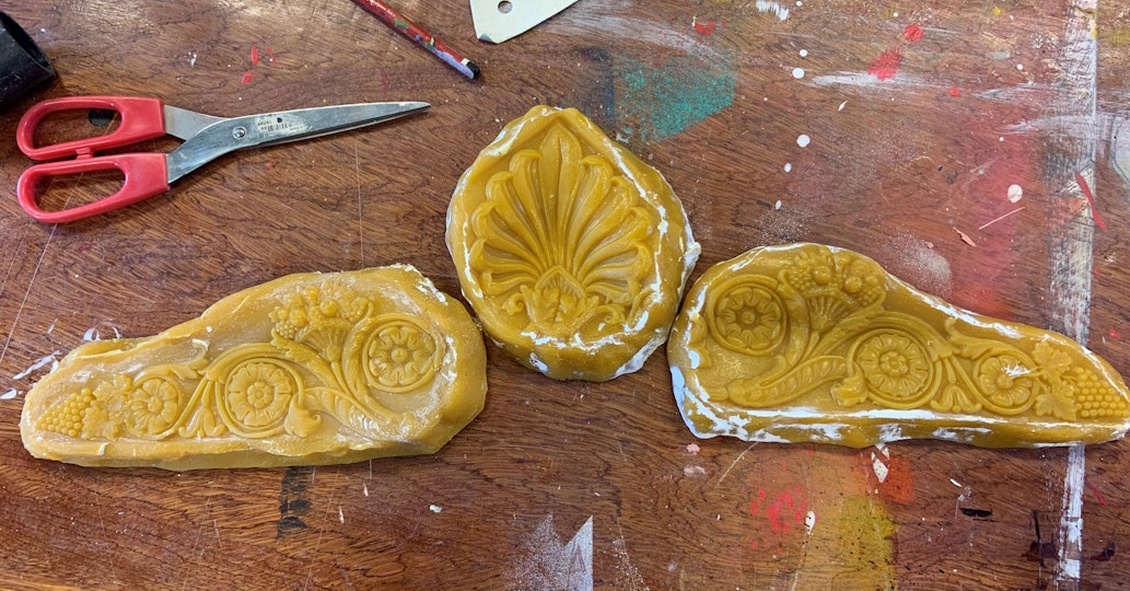 Three impressions for frame ornaments on a work surface with a pair of scissors
