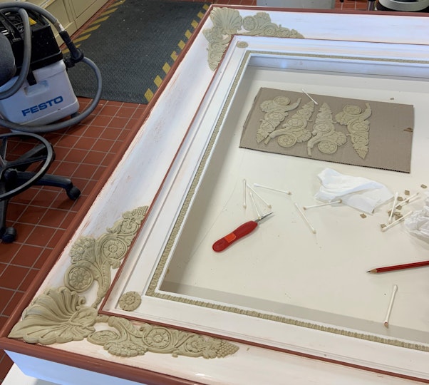 A frame in progress, with some carved ornaments in place