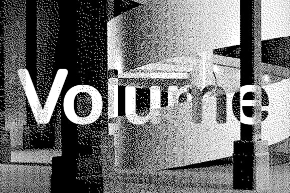 The word Volume superimposed on a grainy image of a spiral staircase and concrete columns.