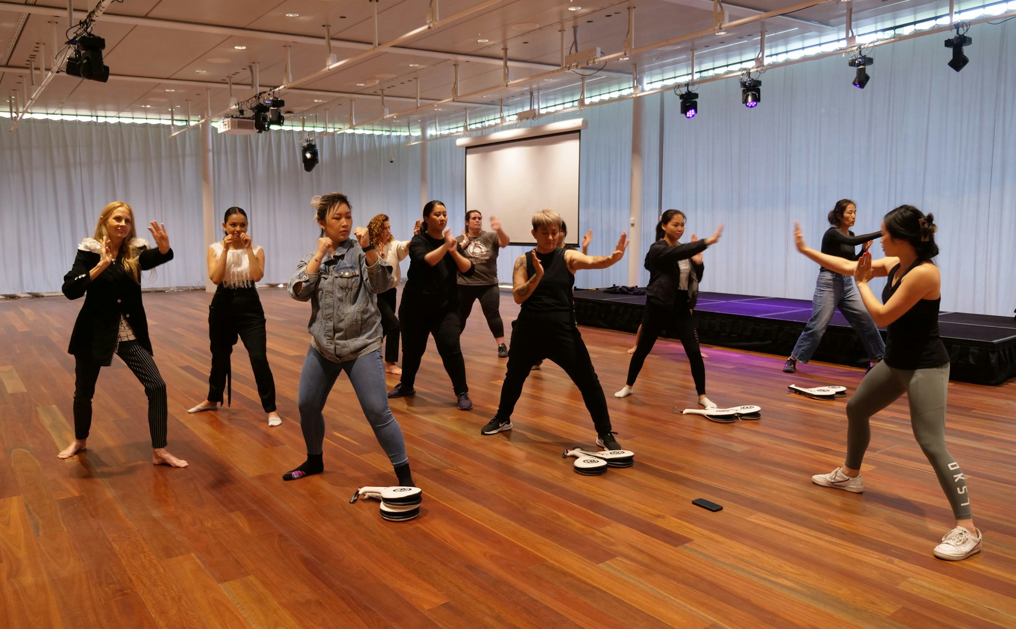 A group of people in a hall, each in a martial arts pose