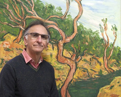 A person sitting in front of a landscape painting