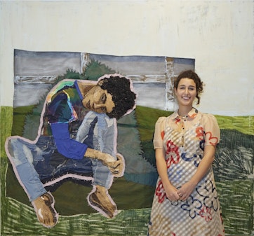 A person stands in front of a collaged painting of a seated figure outdoors