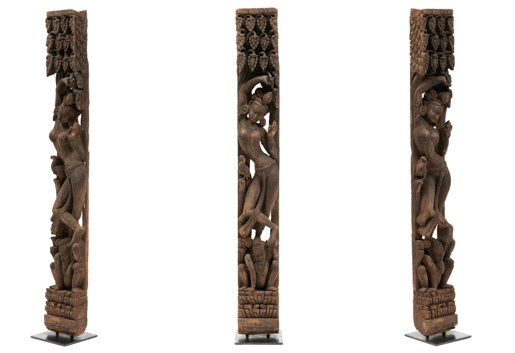A carved wooden column featuring a sinuous figure shown at different angles