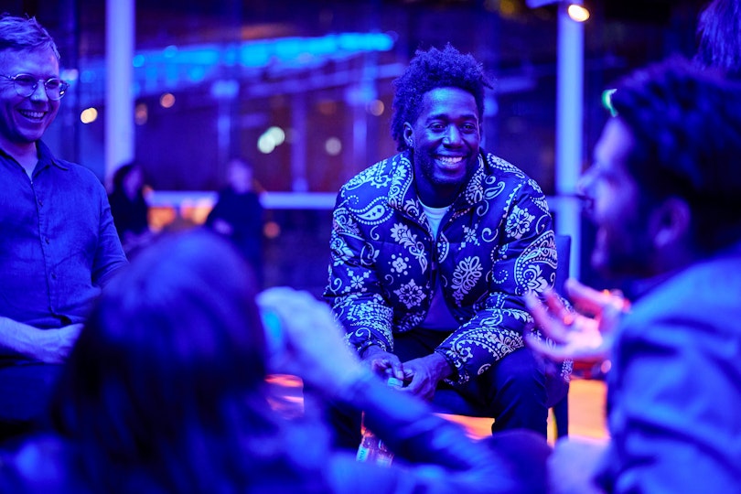 A small group of laughing people sitting in a circle