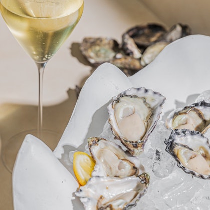 A plate of oysters and a glass of sparkling wine