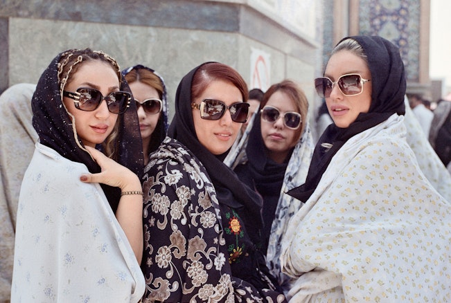 A group of people wearing headscarves and large sunglasses pose for a portrait