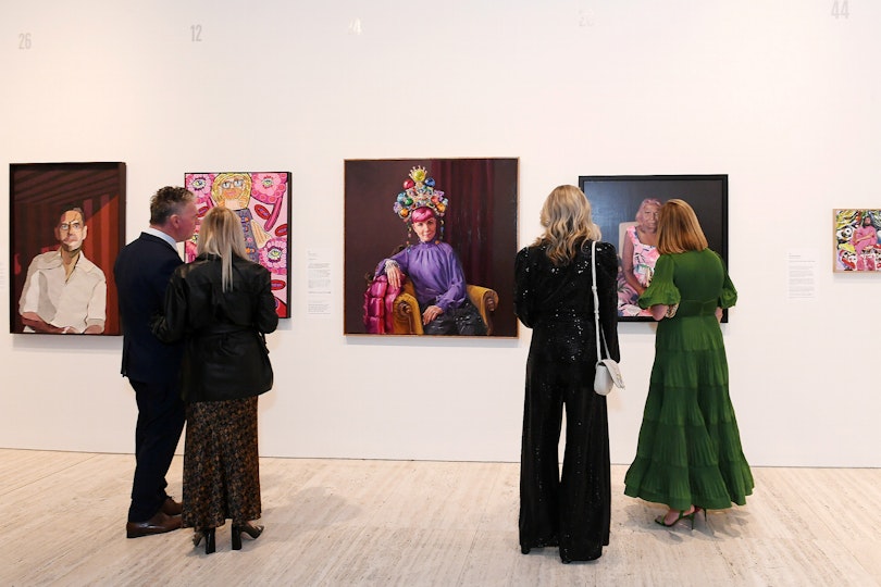 Visitors view the Archibald Prize 2023 exhibition, featuring works by (left-right) Jason Jowett, Emily Crockford, Andrea Huelin, Tsering Hannaford and Kirthana Selvaraj
