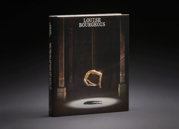 A book with the title Louise Bourgeois and an image of a gold suspended figure sculpture