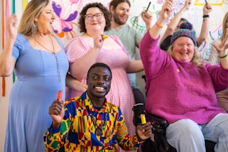 A group of smiling people with raised arms