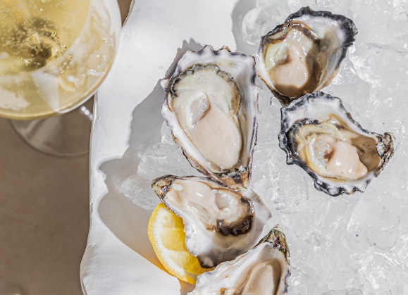 A plate of oysters and a glass of sparkling wine