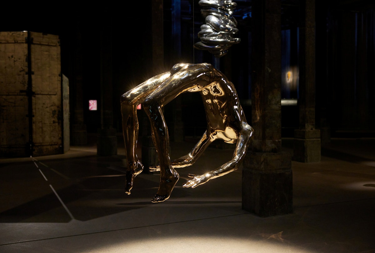 Shiny sculptures suspended within a dark space
