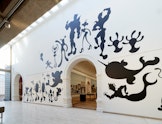 A large mural of silhouetted fantastical figures.