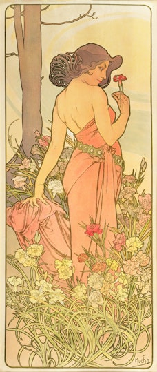 A person in a strapless gown holding a red flower and standing among flowers in front of a tree