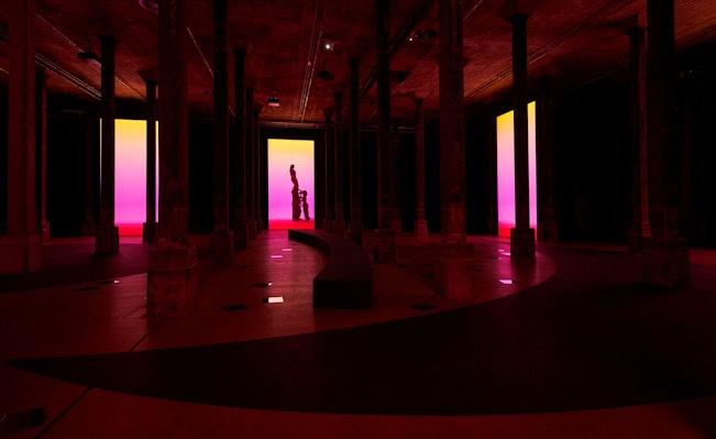 A dark room with large colourful digital screens